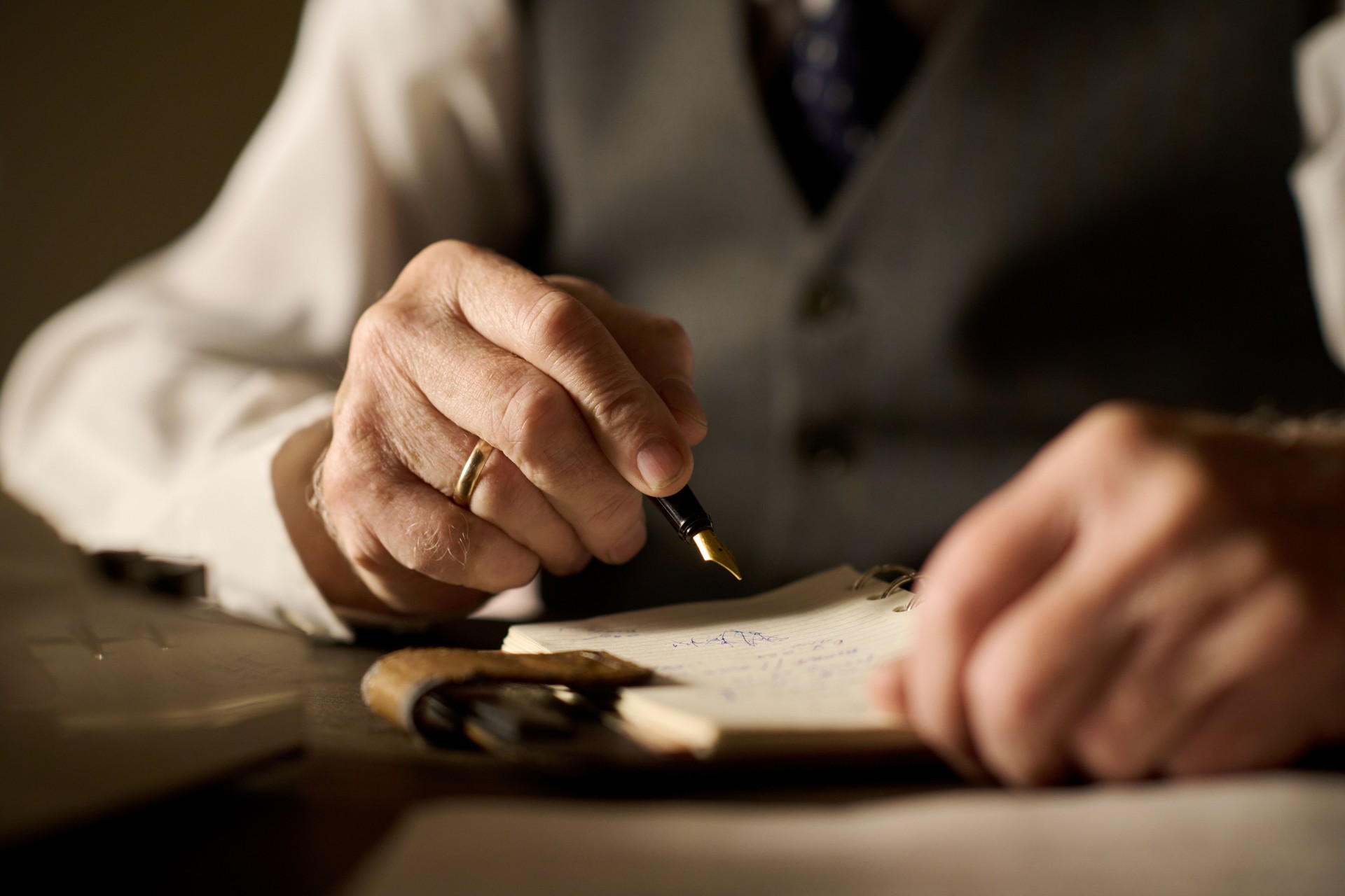 Middle Aged Caucasian Man Writing Notes with Fountain Pen at Desk Middle Aged Caucasian Man Writing Notes with Fountain Pen at Desk
